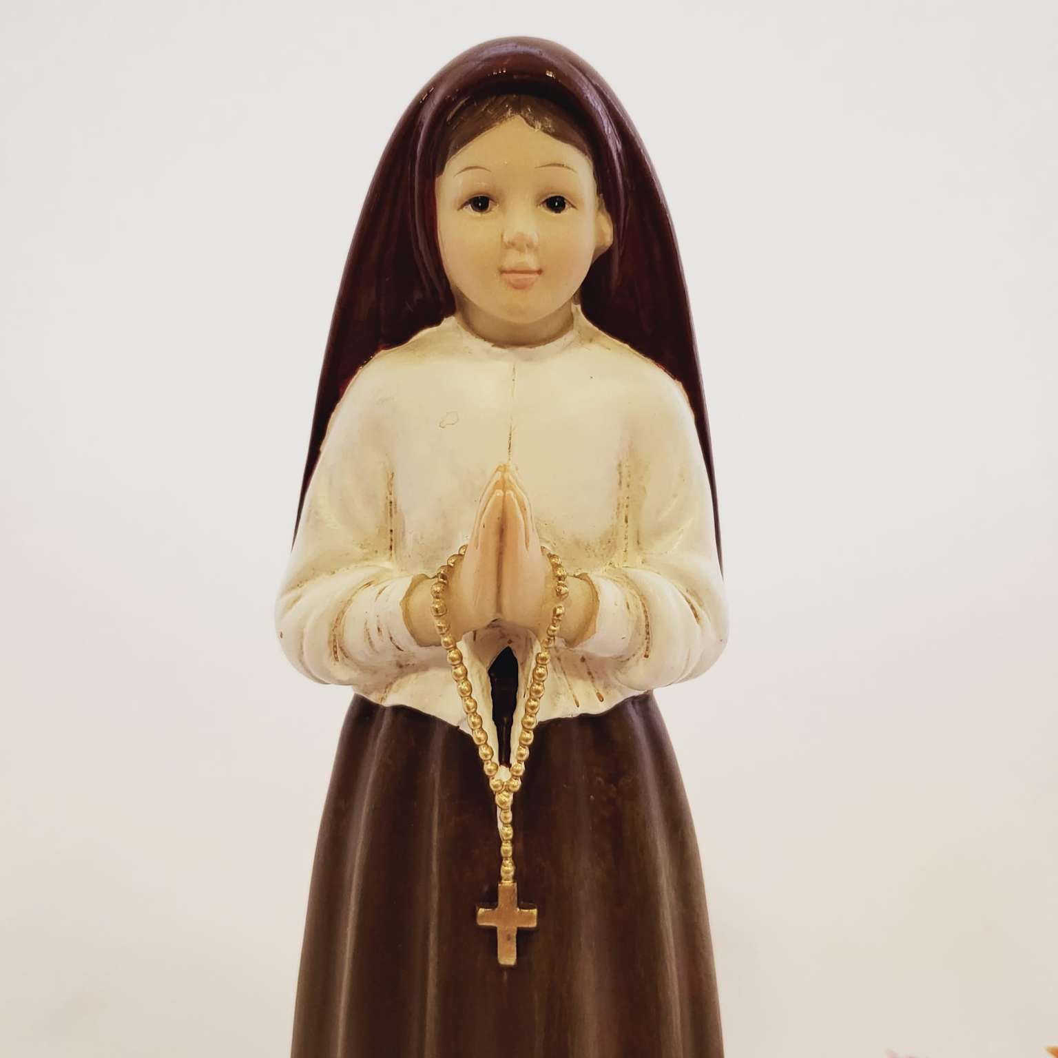 Statue of Saint Jacinta Marto with rosary